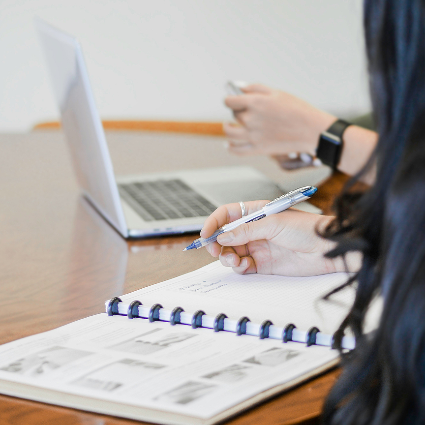 Designer reviewing flooring plans with laptop and notebook