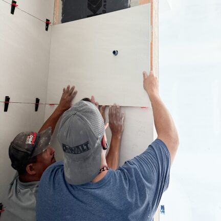 Professional installer fitting material to wall